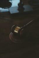 Justice and law concept.Male judge in a courtroom with the gavel, working with, computer and docking keyboard, eyeglasses, on table in morning light photo