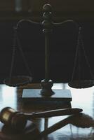 Justice and law concept.Male judge in a courtroom with the gavel, working with, computer and docking keyboard, eyeglasses, on table in morning light photo