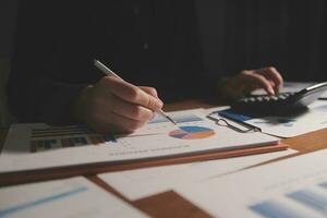Close up businessman hand using calculator and working with laptop calculate about finance accounting at coffeeshop outdor.finance accounting concept photo