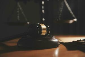 Business and lawyers discussing contract papers with brass scale on desk in office. Law, legal services, advice, justice and law concept picture with film grain effect photo