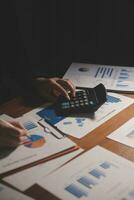 Close up businessman hand using calculator and working with laptop calculate about finance accounting at coffeeshop outdor.finance accounting concept photo