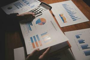 Close up businessman hand using calculator and working with laptop calculate about finance accounting at coffeeshop outdor.finance accounting concept photo