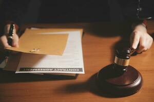 Business and lawyers discussing contract papers with brass scale on desk in office. Law, legal services, advice, justice and law concept picture with film grain effect photo