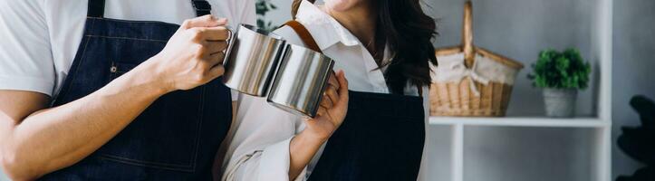 Happy young adult couple making breakfast and drinking coffee together in cozy home kitchen in morning at home. Preparing meal and smiling. Lifestyle, leisure and Love concept. photo