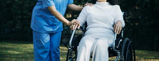 Asian young woman nurse at nursing home take care disabled senior man. Caregiver doctor serve physical therapy for older elderly patient to exercise and practice walking on walker or cane at backyard. photo