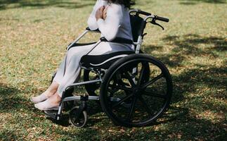 Asian young woman nurse at nursing home take care disabled senior man. Caregiver doctor serve physical therapy for older elderly patient to exercise and practice walking on walker or cane at backyard. photo