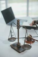 Business and lawyers discussing contract papers with brass scale on desk in office. Law, legal services, advice, justice and law concept picture with film grain effect photo