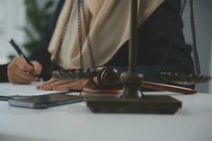 Business and lawyers discussing contract papers with brass scale on desk in office. Law, legal services, advice, justice and law concept picture with film grain effect photo