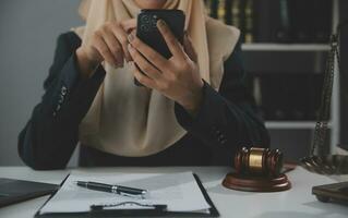 Business and lawyers discussing contract papers with brass scale on desk in office. Law, legal services, advice, justice and law concept picture with film grain effect photo