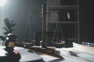 Business and lawyers discussing contract papers with brass scale on desk in office. Law, legal services, advice, justice and law concept picture with film grain effect photo
