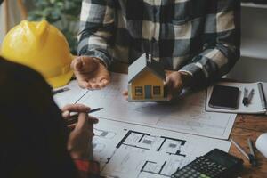 reunión de trabajo en equipo de ingenieros, trabajo de dibujo en la reunión de planos para el trabajo del proyecto con un socio en la construcción de modelos y herramientas de ingeniería en el concepto de sitio de trabajo, construcción y estructura. foto