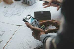 reunión de trabajo en equipo de ingenieros, trabajo de dibujo en la reunión de planos para el trabajo del proyecto con un socio en la construcción de modelos y herramientas de ingeniería en el concepto de sitio de trabajo, construcción y estructura. foto