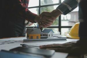 reunión de trabajo en equipo de ingenieros, trabajo de dibujo en la reunión de planos para el trabajo del proyecto con un socio en la construcción de modelos y herramientas de ingeniería en el concepto de sitio de trabajo, construcción y estructura. foto