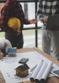 reunión de trabajo en equipo de ingenieros, trabajo de dibujo en la reunión de planos para el trabajo del proyecto con un socio en la construcción de modelos y herramientas de ingeniería en el concepto de sitio de trabajo, construcción y estructura. foto