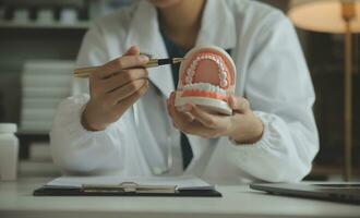 los dentistas están discutiendo problemas dentales al informar la imagen de rayos X en la pantalla del portátil a los pacientes. foto