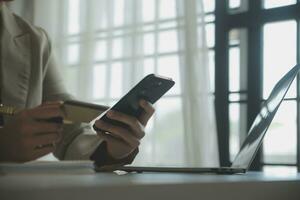 Close up woman hand using credit card and smartphone laptop for buying online shopping photo