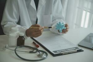 Doctor and patient sitting and talking at medical examination at hospital office, close-up. Therapist filling up medication history records. Medicine and healthcare concept. photo