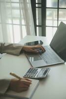 Businesswoman or accountant working Financial investment on calculator, calculate, analyze business and marketing growth on financial document data graph, Accounting, Economic, commercial concept. photo