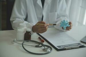 Doctor and patient sitting and talking at medical examination at hospital office, close-up. Therapist filling up medication history records. Medicine and healthcare concept. photo