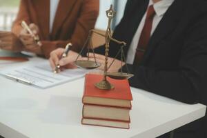 Business and lawyers discussing contract papers with brass scale on desk in office. Law, legal services, advice, justice and law concept picture with film grain effect photo