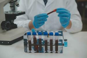 Scientist or medical in lab coat working in biotechnological laboratory, Microscope equipment for research with mixing reagents in glass flask in clinical laboratory. photo