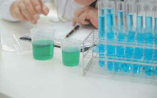 Scientist or medical in lab coat working in biotechnological laboratory, Microscope equipment for research with mixing reagents in glass flask in clinical laboratory. photo