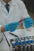 Scientist or medical in lab coat working in biotechnological laboratory, Microscope equipment for research with mixing reagents in glass flask in clinical laboratory. photo