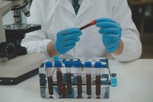 Scientist or medical in lab coat working in biotechnological laboratory, Microscope equipment for research with mixing reagents in glass flask in clinical laboratory. photo