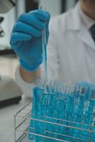 Scientist or medical in lab coat working in biotechnological laboratory, Microscope equipment for research with mixing reagents in glass flask in clinical laboratory. photo