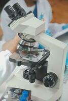 Scientist or medical in lab coat working in biotechnological laboratory, Microscope equipment for research with mixing reagents in glass flask in clinical laboratory. photo