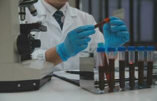 Scientist or medical in lab coat working in biotechnological laboratory, Microscope equipment for research with mixing reagents in glass flask in clinical laboratory. photo