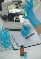 Scientist or medical in lab coat working in biotechnological laboratory, Microscope equipment for research with mixing reagents in glass flask in clinical laboratory. photo