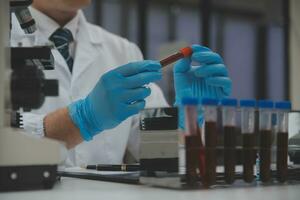 Scientist or medical in lab coat working in biotechnological laboratory, Microscope equipment for research with mixing reagents in glass flask in clinical laboratory. photo