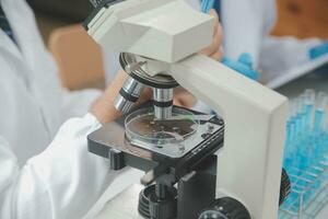 Scientist or medical in lab coat working in biotechnological laboratory, Microscope equipment for research with mixing reagents in glass flask in clinical laboratory. photo