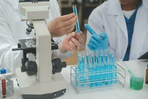 Scientist or medical in lab coat working in biotechnological laboratory, Microscope equipment for research with mixing reagents in glass flask in clinical laboratory. photo