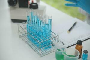 Scientist or medical in lab coat working in biotechnological laboratory, Microscope equipment for research with mixing reagents in glass flask in clinical laboratory. photo