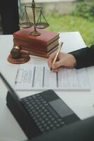 Business and lawyers discussing contract papers with brass scale on desk in office. Law, legal services, advice, justice and law concept picture with film grain effect photo