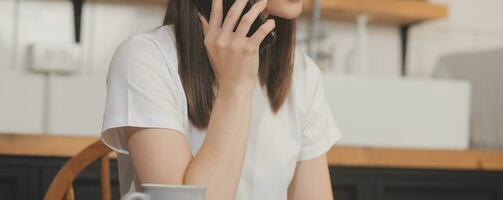 Cropped photo of Freelancer business Asian woman holding coffee cup and at doing planning analyzing the financial report, business plan investment, finance analysis the workplace.