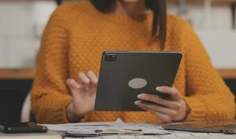 Cropped photo of Freelancer business Asian woman holding coffee cup and at doing planning analyzing the financial report, business plan investment, finance analysis the workplace.