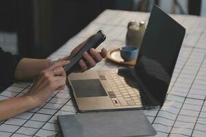 Cropped photo of Freelancer business Asian woman holding coffee cup and at doing planning analyzing the financial report, business plan investment, finance analysis the workplace.