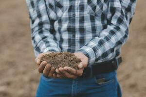 símbolo corazón tierra día. puñado de suciedad manos corazón forma. granja orgánico tierra. granjero manos suelo suelo tierra suciedad jardín suelo granja suelo. masculino manos lleno de fértil tierra campo agricultura concepto foto