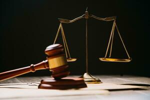 Justice and law concept.Male judge in a courtroom with the gavel, working with, computer and docking keyboard, eyeglasses, on table in morning light photo