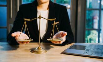 Justice and law concept.Male judge in a courtroom with the gavel, working with, computer and docking keyboard, eyeglasses, on table in morning light photo