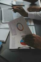 Financial analysts analyze business financial reports on a digital tablet planning investment project during a discussion at a meeting of corporate showing the results of their successful teamwork. photo