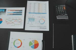 Financial analysts analyze business financial reports on a digital tablet planning investment project during a discussion at a meeting of corporate showing the results of their successful teamwork. photo