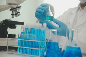 investigadores de atención médica que trabajan en el laboratorio de ciencias de la vida. joven científica investigadora y supervisora masculina senior preparando y analizando portaobjetos de microscopio en el laboratorio de investigación. foto