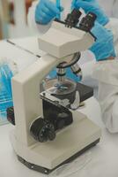 Health care researchers working in life science laboratory. Young female research scientist and senior male supervisor preparing and analyzing microscope slides in research lab. photo