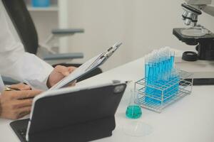 Health care researchers working in life science laboratory. Young female research scientist and senior male supervisor preparing and analyzing microscope slides in research lab. photo