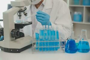 investigadores de atención médica que trabajan en el laboratorio de ciencias de la vida. joven científica investigadora y supervisora masculina senior preparando y analizando portaobjetos de microscopio en el laboratorio de investigación. foto