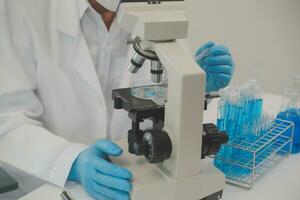 investigadores de atención médica que trabajan en el laboratorio de ciencias de la vida. joven científica investigadora y supervisora masculina senior preparando y analizando portaobjetos de microscopio en el laboratorio de investigación. foto